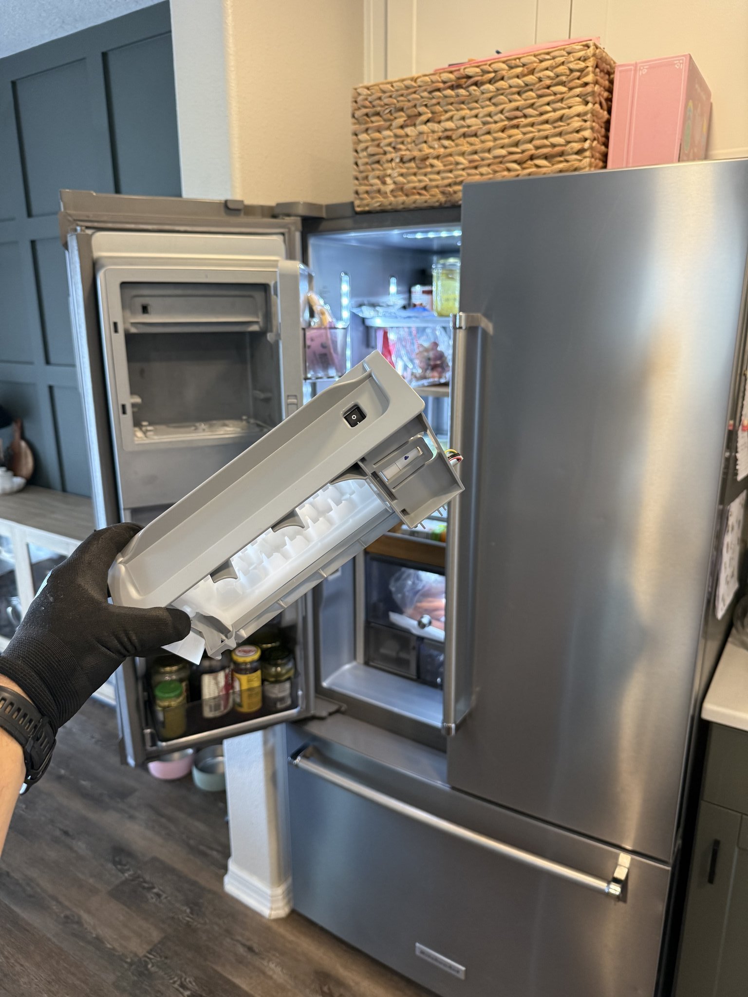Fixer Service technician removing ice maker assembly during Whirlpool refrigerator repair in Palm Harbor FL